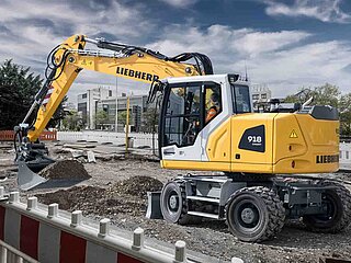 Kompaktbagger Liebherr A 918 Compact verteilt Erdmaterial auf Baustelle in der Innenstadt