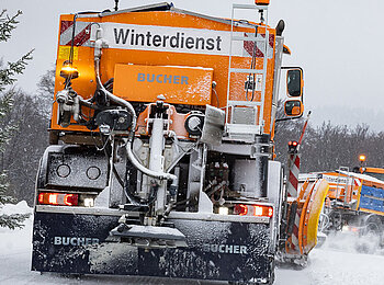 Ein Unimog mit Streuautomaten-Aufbau von hinten. 