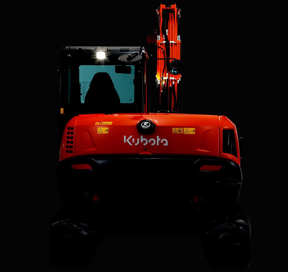 Der Kubota KX085-5 im Dunkeln beleuchtet.