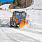 Ein orangefarbenes Fahrzeug mit Schneepflug