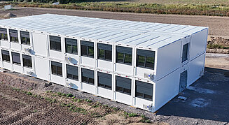 Zweigeschossige Container-Schule von Recon auf einer Baustelle, aus der Luft fotografiert