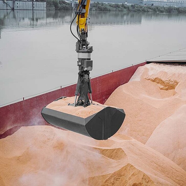 Ein Liebherr-Mehrschalengreifer entlädt Sand von einem Schiff. 