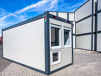 Beutlhauser Bürocontainer mit Fenster auf einem Hof voller Container